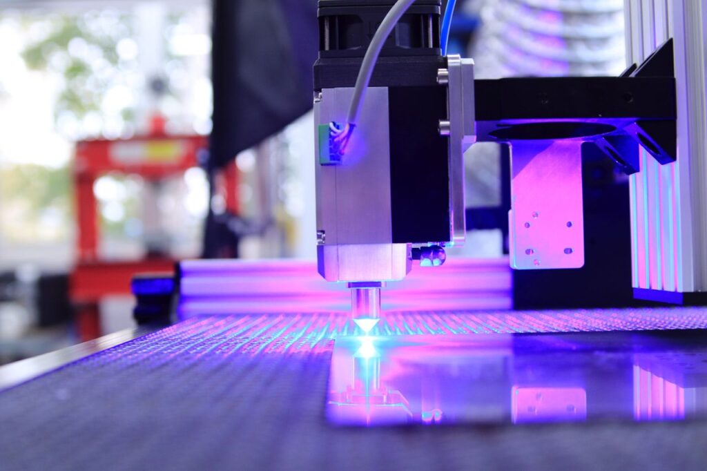 pexels-photo-7254410-7254410 Close-up of a laser engraving machine working indoors with blue light reflection.
